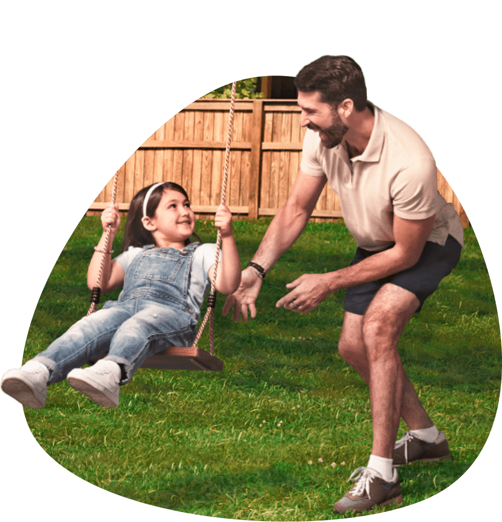 A father pushing his daughter on a swing